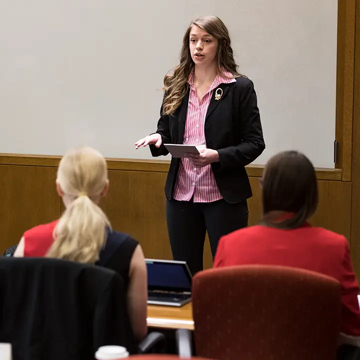 Woman speaking in front of room