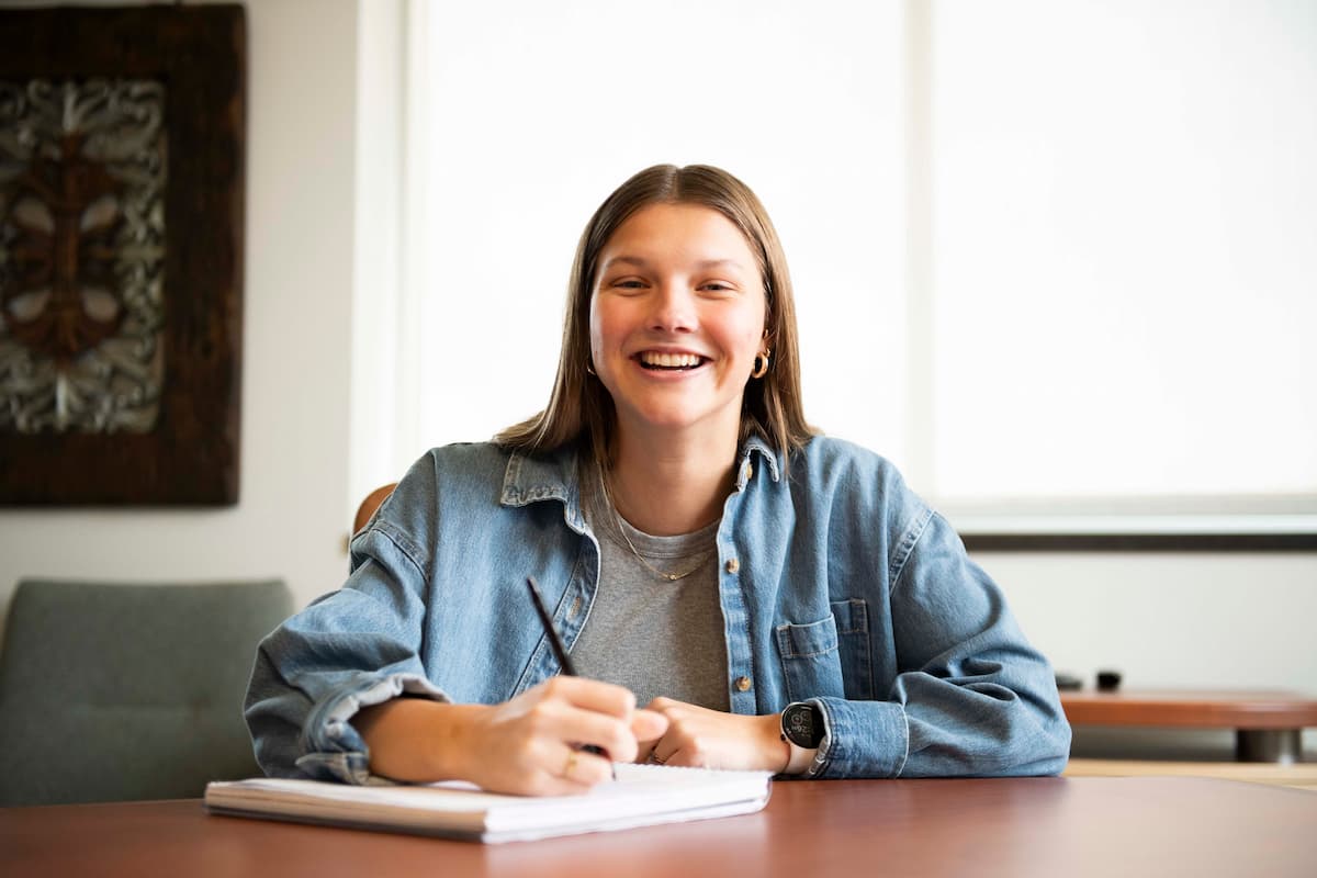 a female student writes on a notepad.