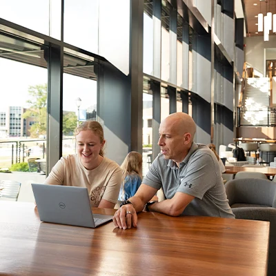 Professor and student looking at laptop and talking.