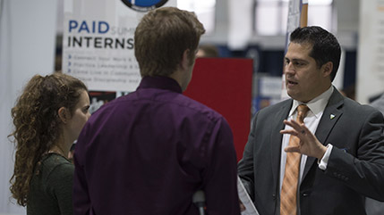 Recruiter talking to two students during a Cedarville University career fair
