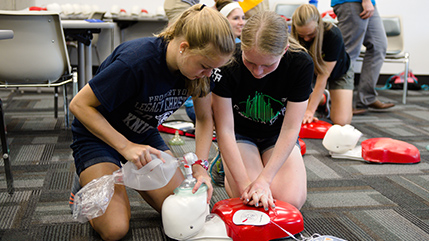 Two Cedarville nursing students perform CPR on a mannequin. 