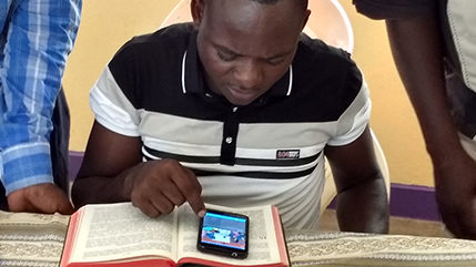 Man reading Bible story on a smartphone.