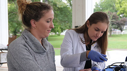 Cedarville University Doctor of Pharmacy student doing a blood draw from a patient. 