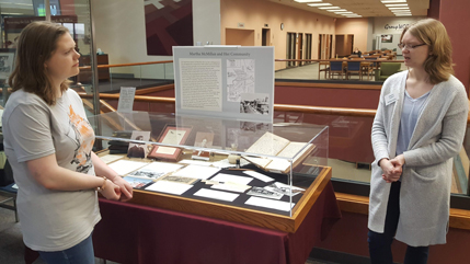 Students discussing Martha McMillan journals at Centennial Library display