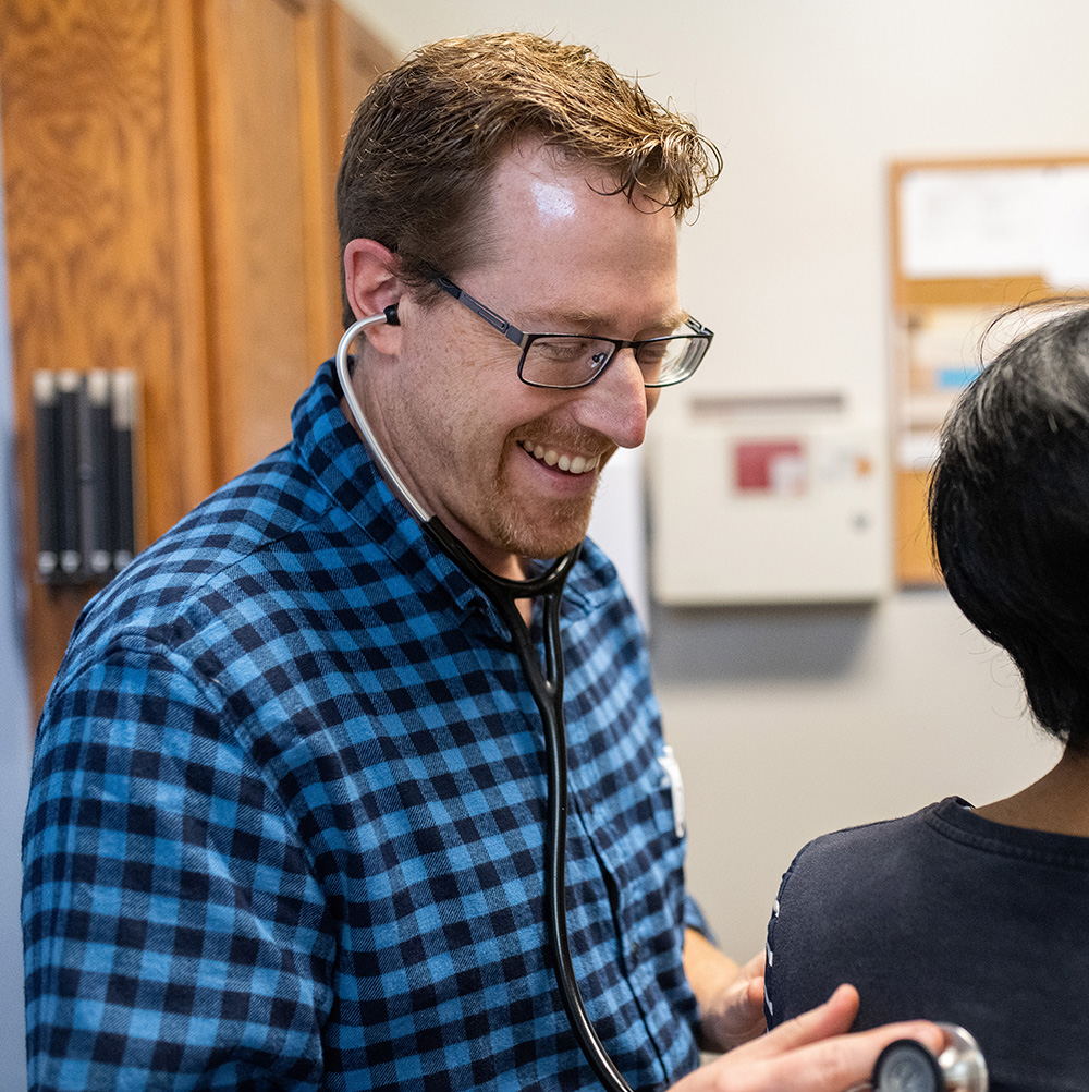 Dr. Brad VanHeukelum examines a patient at His Branches Clinic in Rochester, New York