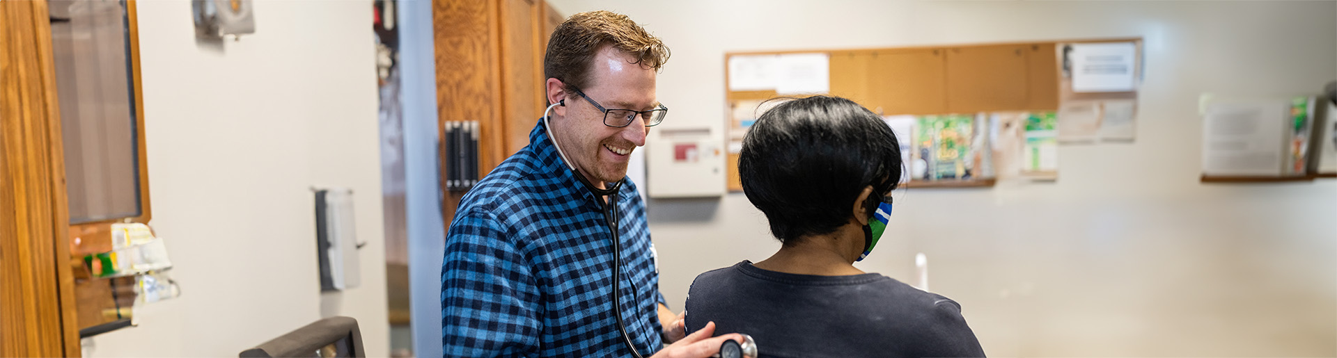 Dr. Brad VanHeukelum examines a patient at His Branches Clinic in Rochester, New York