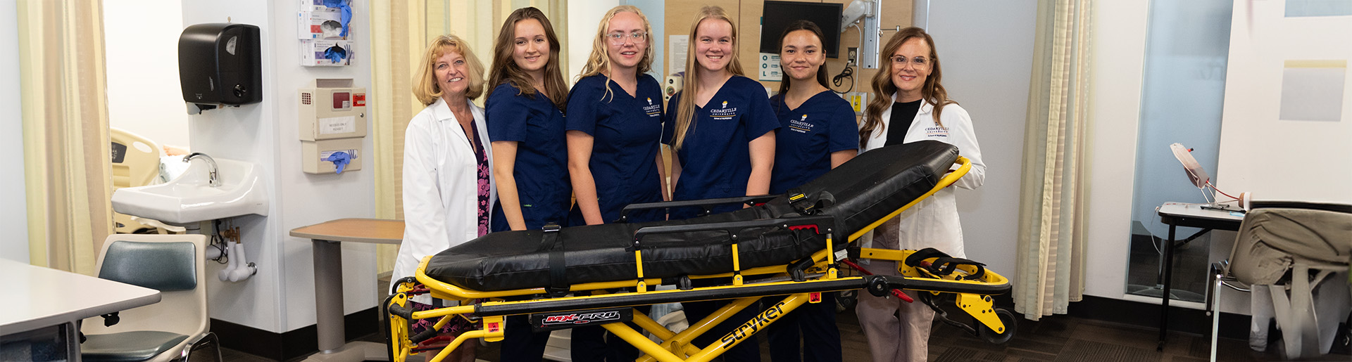 Nursing faculty and students with new Stryker stretcher 1920