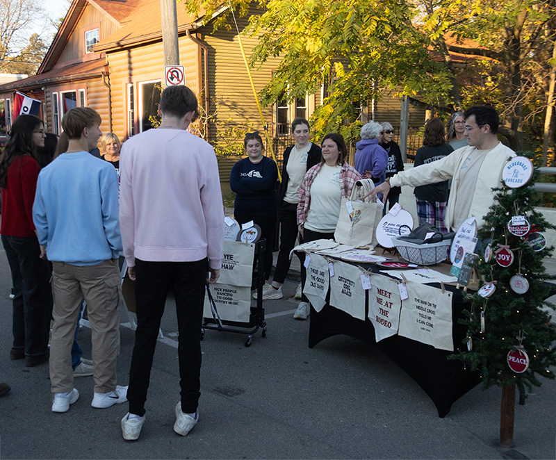 Timothy Goodman answers questions about the products he sells through his business Blue Grass Threads at a Sidewalk Saturday event.