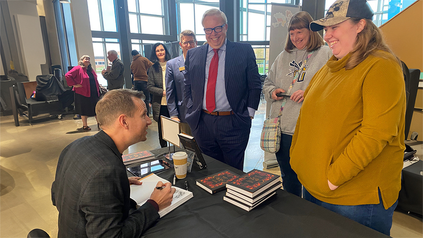 Dan Jacobsen, grandson of the late Warren Wiersbe, signs copies of the final work of his grandfather which he was privileged to edit.