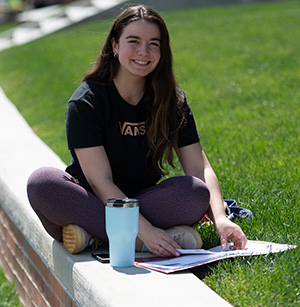 Student works online in an outdoor setting.