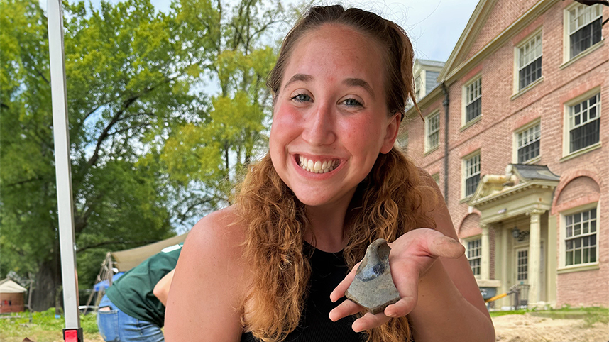 Cedarville student Mary Madigan holds an artifact she helped recover at the Williamsburg Bray School archeological site in Williamsburg, Virginia.