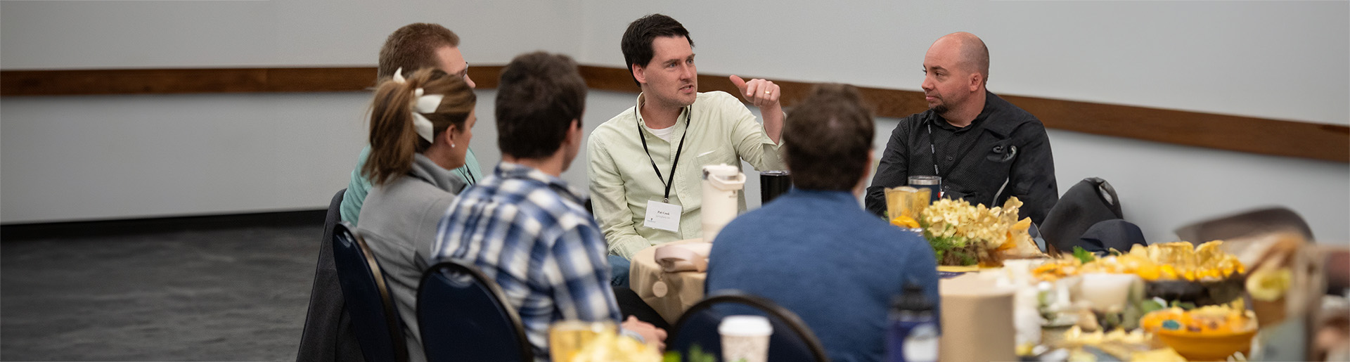 Conference attendees talking together around a round table.