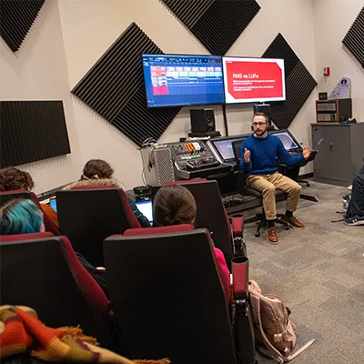 Instructor teaches audio production students in a classroom equipped with professional recording and mixing technology.
