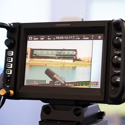 Camera monitor displaying a live video production scene during filming