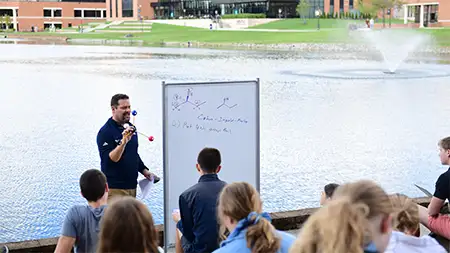 Faculty teaching a class beside the lake