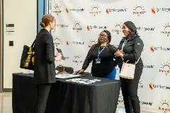 Two women engaged in conversation at a networking table