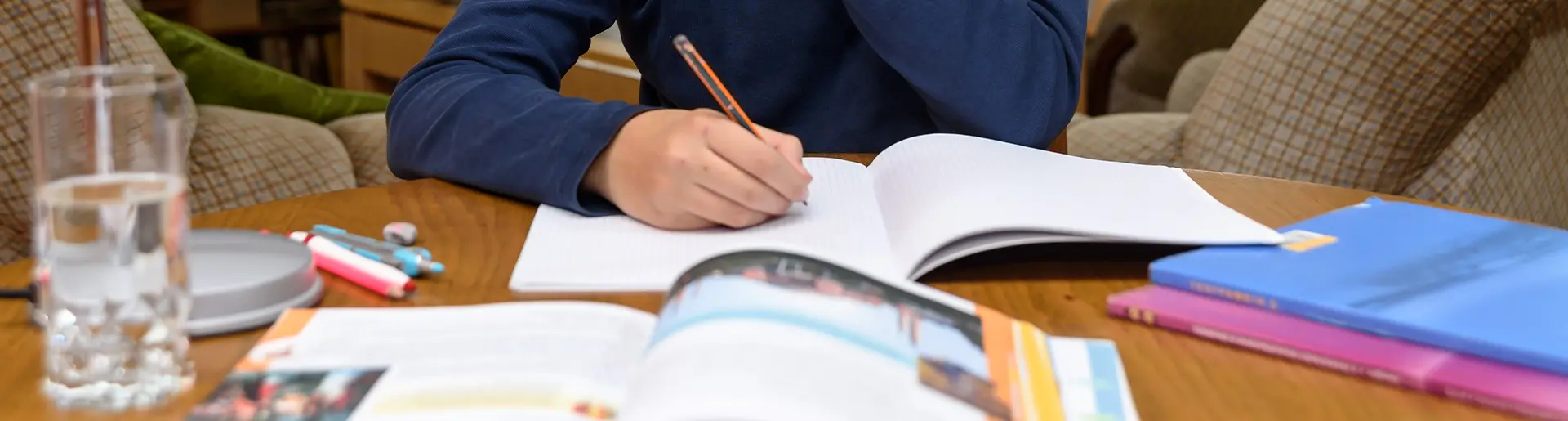 Student sitting at a table at home completing schoolwork