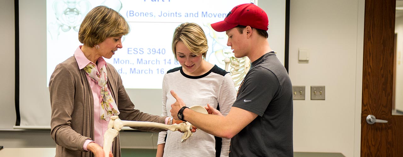 Professor and two students examine a bone