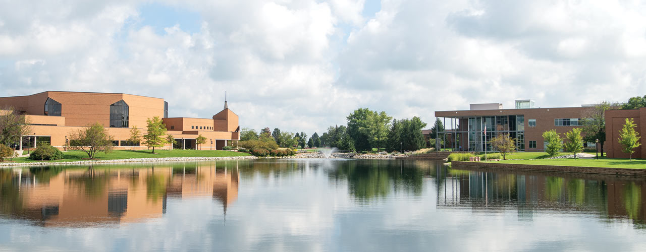 Image of Cedarville campus: Dixon ministry center, Cedar-lake and Biblical and Theological Studies Center are shown on a clear summer day
